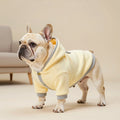 Handcrafted luxury dog outerwear presenting a pale yellow fleece hoodie with contrasting ribbed edges and chest buttons.